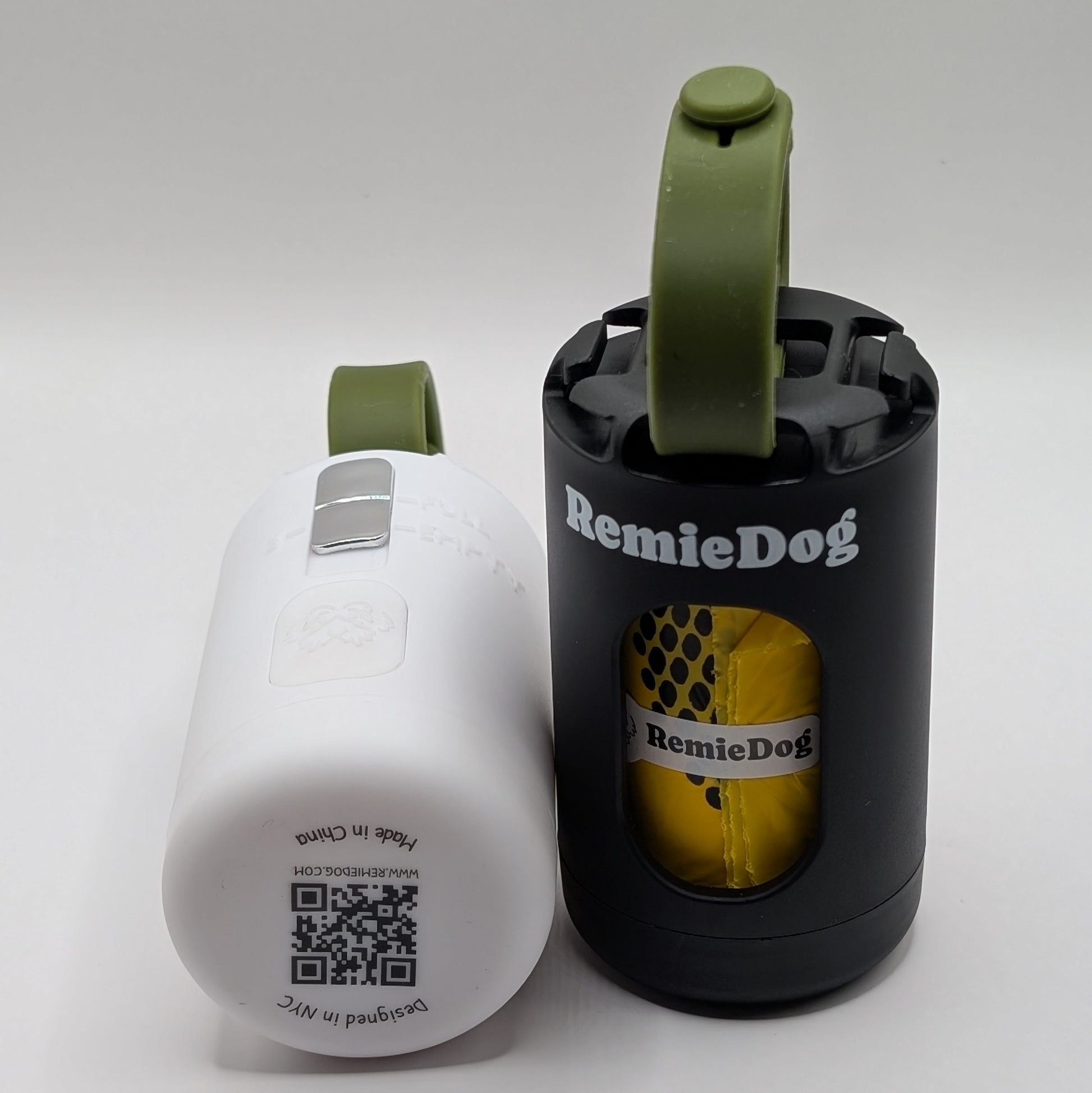 black and white remiedog poop bag holder with green straps next to each other