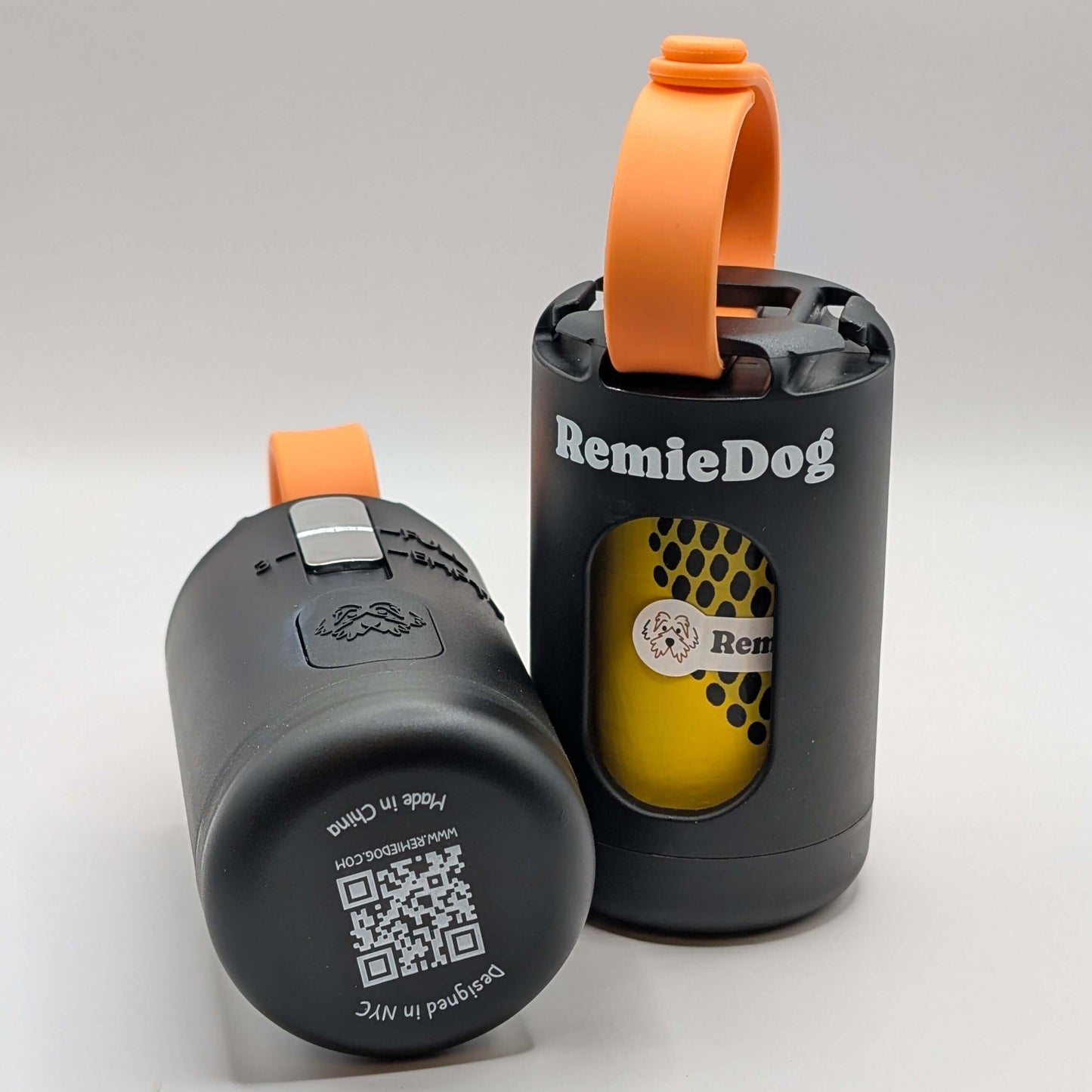 Two black dog poop bag holders with orange strap with RemieDog branding