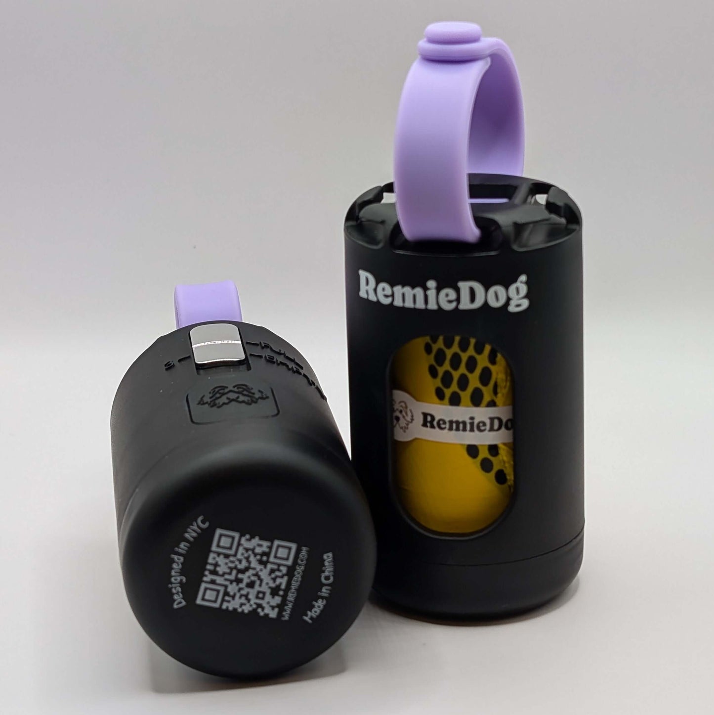 Two black dog poop bag holders with purple strap with RemieDog branding