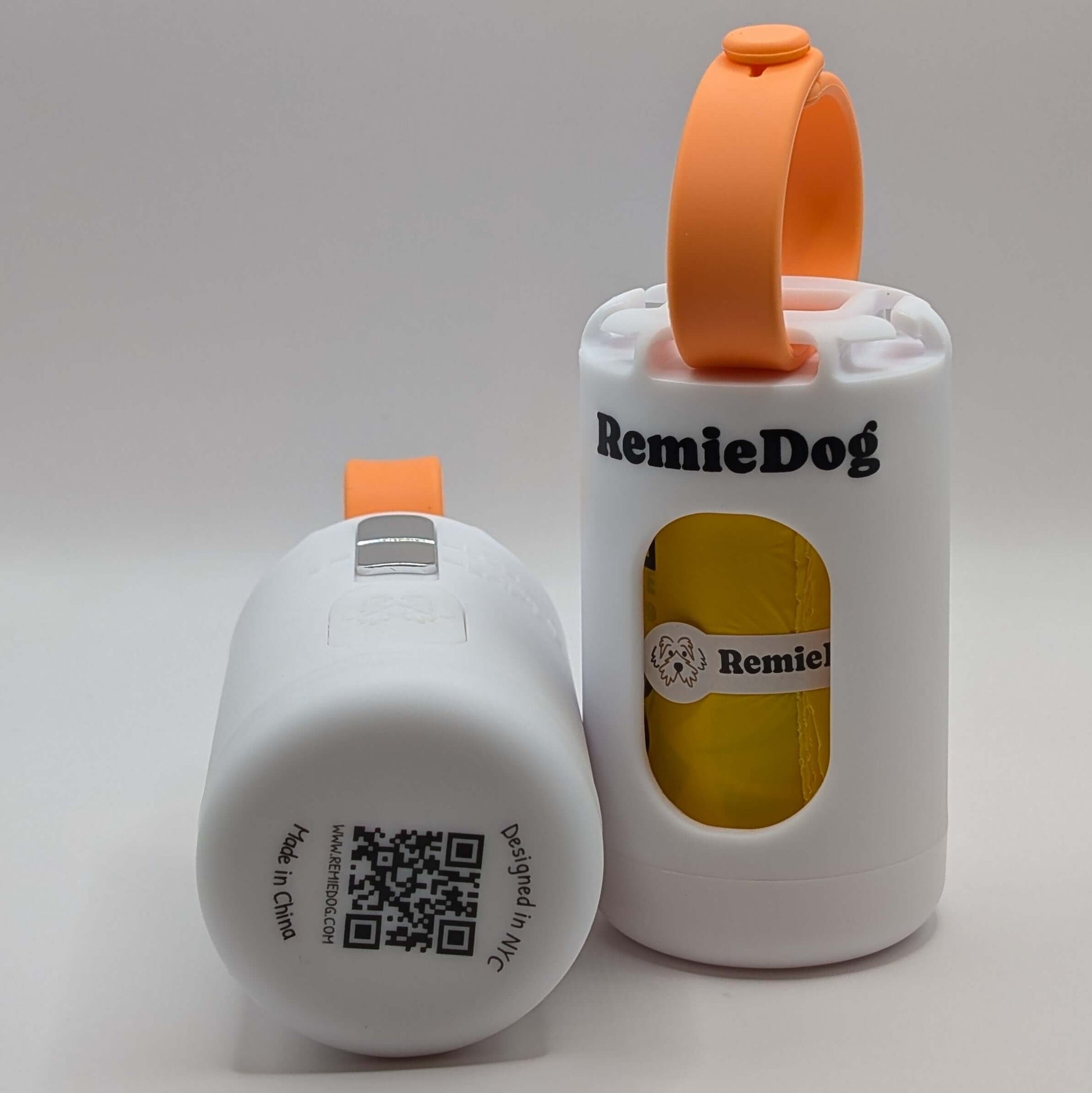 Two white dog poop bag holders with orange strap with RemieDog branding